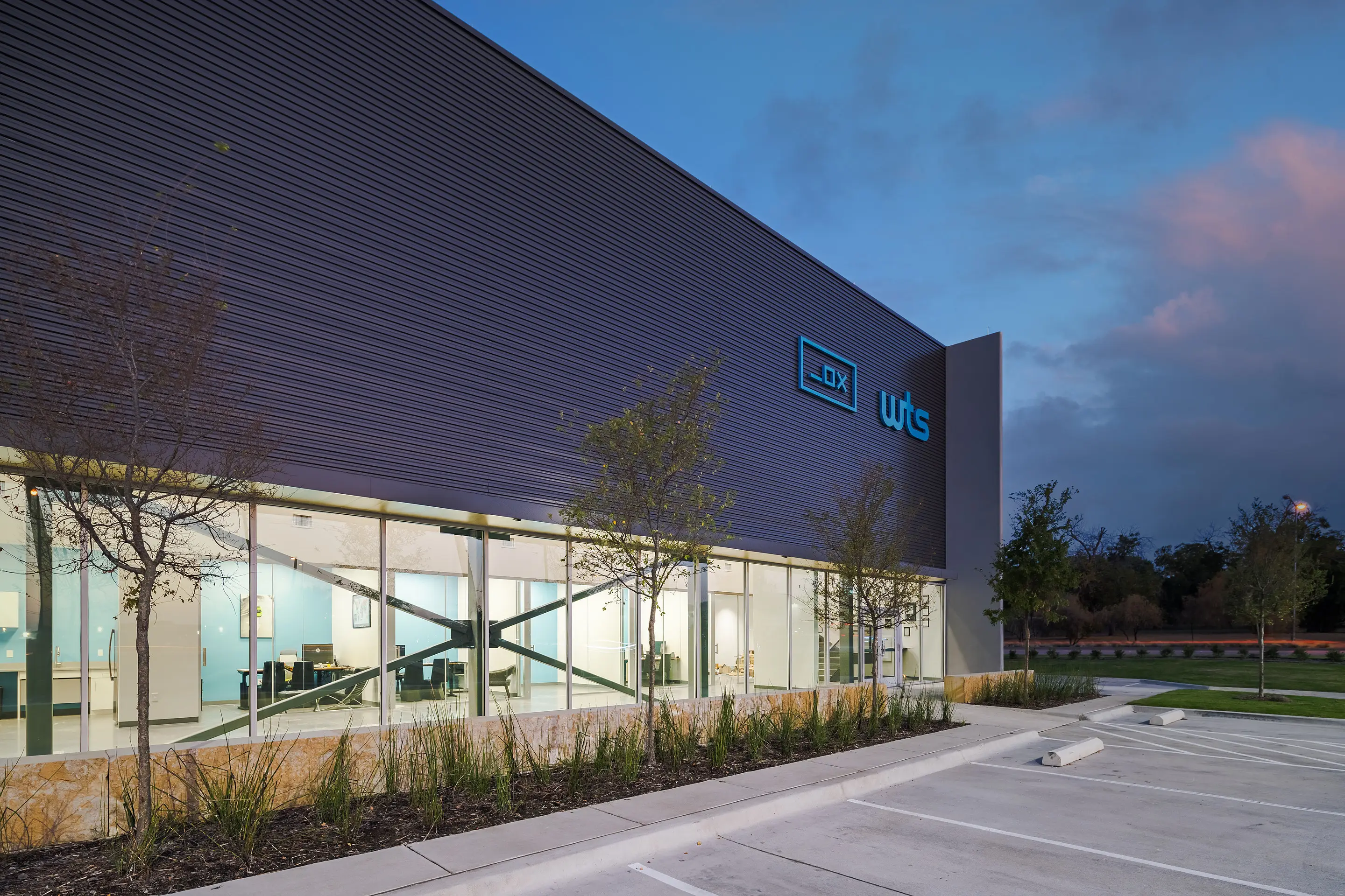 The glazed office frontage of the WesternTechSystems facility at blue hour