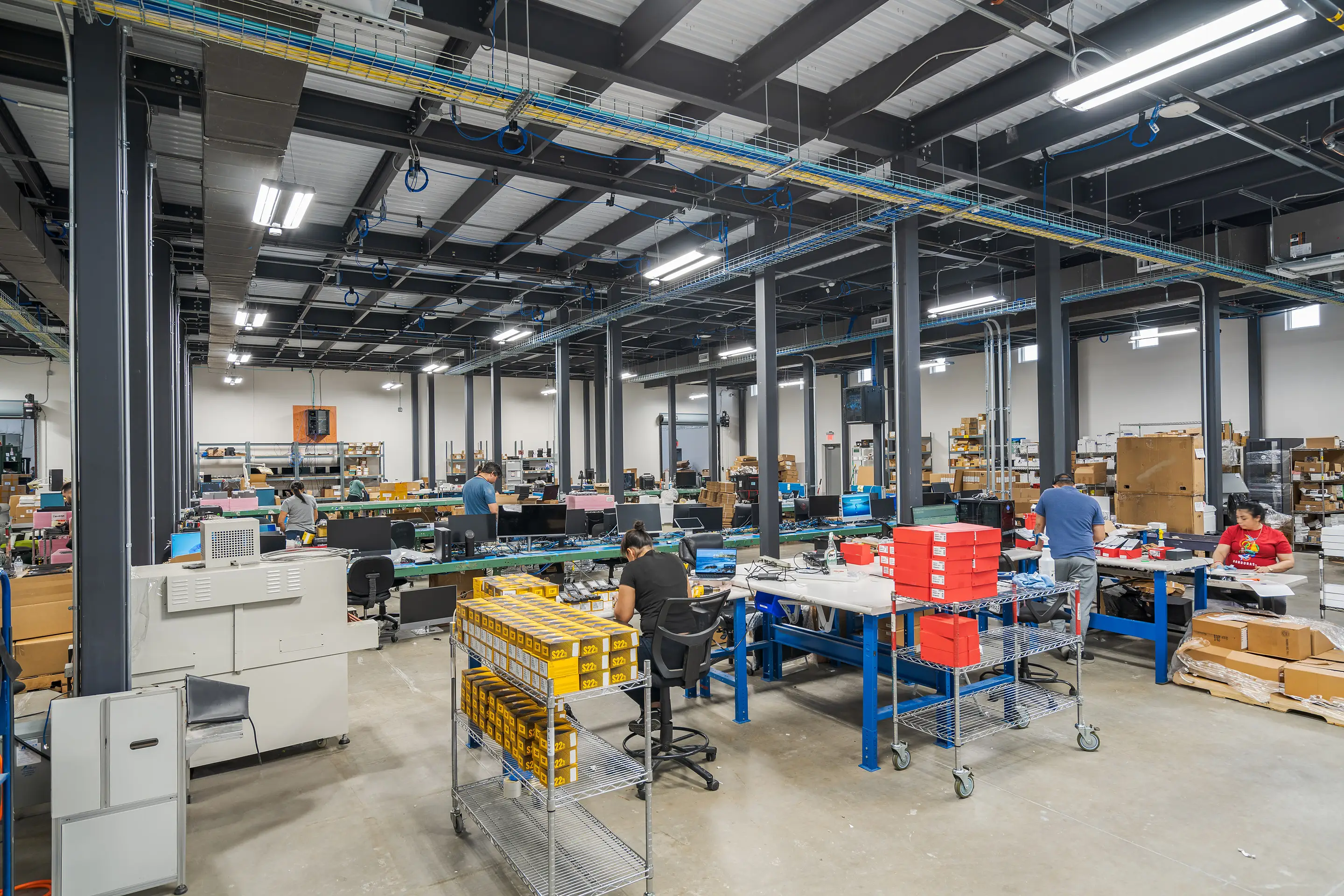 Technicians at workbenches on the WesternTechSystems processing floor